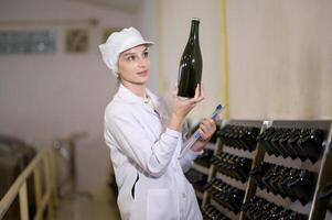 Professional winemaker controlling wine making process and quality at winery factory photo