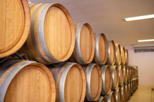 Old wooden wine barrels stacked in a cellar in order photo