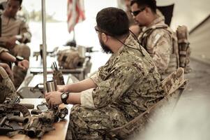 Soldiers in camouflage uniforms planning on operation in the camp, soldiers training in a military operation photo