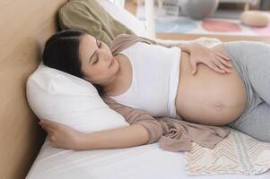 embarazada mujer dormido en el cama, el embarazo y expectativa concepto foto