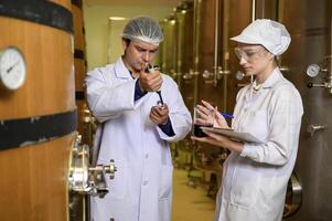 Professional winemaker controlling wine making process and quality at winery factory photo