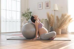 Healthy pregnant woman exercising and doing prenatal yoga, meditation, working out, yoga, pregnancy concept. photo