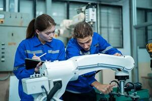 un grupo de robótica ingenieros trabajando con programación y manipulando robot mano, industrial robótica diseño, alto tecnología instalación, moderno máquina aprendiendo. masa producción automáticas. foto