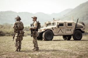 unido estados Ejército en camuflaje uniformes operación en el bosque con blindado vehículo, soldados formación en un militar operación foto