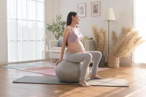 Healthy pregnant woman exercising and doing prenatal yoga, meditation, working out, yoga, pregnancy concept. photo