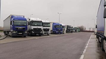 Polen, Jaroslaw 10.04.2024 Lastwagen geparkt im ein sich ausruhen Bereich, mehrere Lastwagen sind geparkt im ein sich ausruhen Bereich entlang ein Straße, präsentieren ein verbreitet Szene im Logistik und Transport. video