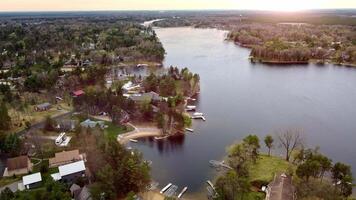 Aerial view of lakeside community, An aerial view of a serene lakeside community with houses, docks, and lush green trees video