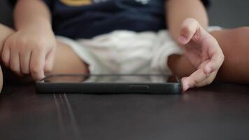 Closeup of children hand using phone on sofa in house video