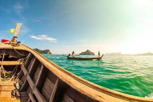 Aerial panorama of Thailand's verdant, lush tropical island, National Park Island, with blue and aquamarine the sea, and clouds shining by sunlight in the background. photo