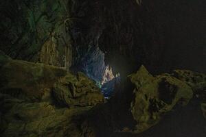 The beautiful views of the stalactite and stalagmite-filled cave in Lam Khlong Ngu National Park, Thailand. At the cave's exit is a small waterfall also. photo