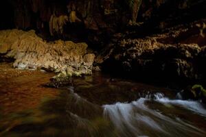 el hermosa puntos de vista de el estalactita y lleno de estalagmitas cueva en justicia khlong ngu nacional parque, tailandia a el cueva salida es un pequeño cascada también. foto