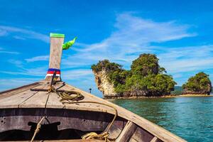 Aerial panorama of Thailand's verdant, lush tropical island, National Park Island, with blue and aquamarine the sea, and clouds shining by sunlight in the background. photo