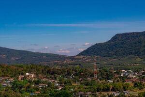 Aerial panorama, there is a well-known tourist destination with views of the mountains, village, and a farm. photo