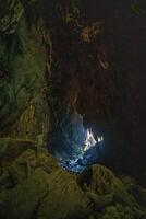 The beautiful views of the stalactite and stalagmite-filled cave in Lam Khlong Ngu National Park, Thailand. At the cave's exit is a small waterfall also. photo