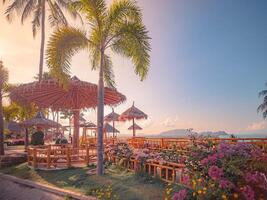 Beach chairs and umbrella on a tropical paradise island by the sea, under a sunny sky. photo