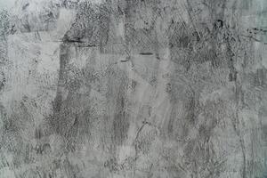 A close up of a grey concrete wall with a rough texture. photo