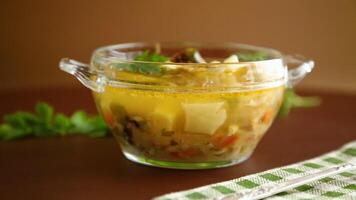 Homemade chicken vegetable soup on rustic wooden background video