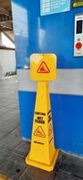 Caution wet floor sign cone at train station. Bekasi, West Java, Indonesia - April 8 2024 photo