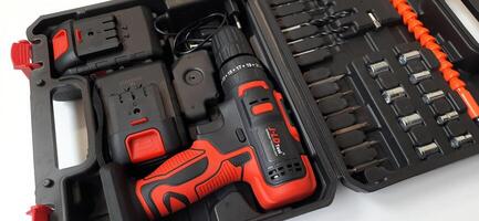 Electric red cordless screwdriver drill with charge the battery isolated on white background. Professional home repair tool. Bekasi, West Java, Indonesia - May 17 2024 photo