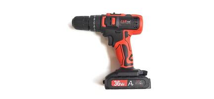 Electric red cordless screwdriver drill with charge the battery isolated on white background. Professional home repair tool. Bekasi, West Java, Indonesia - May 17 2024 photo