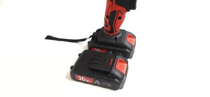Electric red cordless screwdriver drill with charge the battery isolated on white background. Professional home repair tool. Bekasi, West Java, Indonesia - May 17 2024 photo