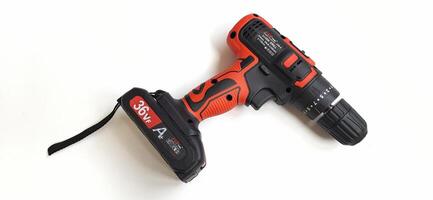 Electric red cordless screwdriver drill with charge the battery isolated on white background. Professional home repair tool. Bekasi, West Java, Indonesia - May 17 2024 photo