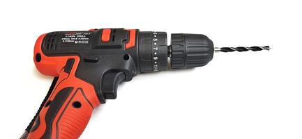 Electric red cordless screwdriver drill with charge the battery isolated on white background. Professional home repair tool. Bekasi, West Java, Indonesia - May 17 2024 photo