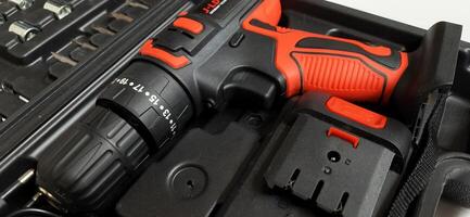 Electric red cordless screwdriver drill with charge the battery isolated on white background. Professional home repair tool. Bekasi, West Java, Indonesia - May 17 2024 photo