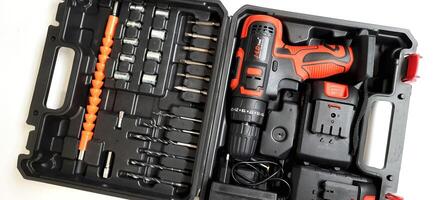 Electric red cordless screwdriver drill with charge the battery isolated on white background. Professional home repair tool. Bekasi, West Java, Indonesia - May 17 2024 photo