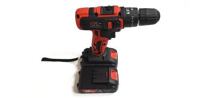 Electric red cordless screwdriver drill with charge the battery isolated on white background. Professional home repair tool. Bekasi, West Java, Indonesia - May 17 2024 photo