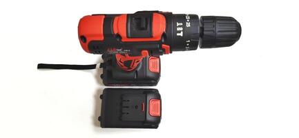 Electric red cordless screwdriver drill with charge the battery isolated on white background. Professional home repair tool. Bekasi, West Java, Indonesia - May 17 2024 photo
