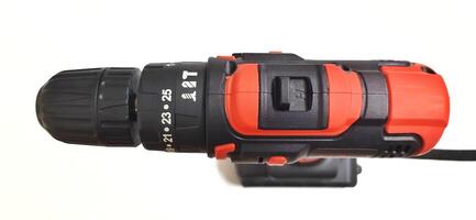 Electric red cordless screwdriver drill with charge the battery isolated on white background. Professional home repair tool. Bekasi, West Java, Indonesia - May 17 2024 photo