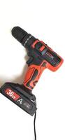 Electric red cordless screwdriver drill with charge the battery isolated on white background. Professional home repair tool. Bekasi, West Java, Indonesia - May 17 2024 photo