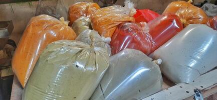 Various condiments or bumbu giling or bumbu halus ingredients in plastic packaging for cuisine, sold in Indonesian local market photo