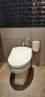 WC or white toilet bowl with flushing water photo
