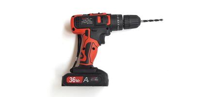 Electric red cordless screwdriver drill with charge the battery isolated on white background. Professional home repair tool. Bekasi, West Java, Indonesia - May 17 2024 photo