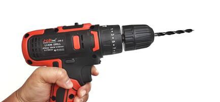 Electric red cordless screwdriver drill with charge the battery isolated on white background. Professional home repair tool. Bekasi, West Java, Indonesia - May 17 2024 photo