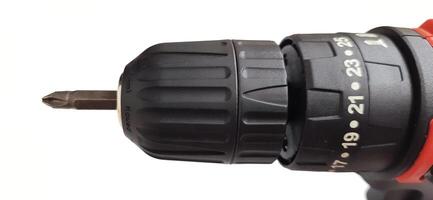 Electric red cordless screwdriver drill with charge the battery isolated on white background. Professional home repair tool. Bekasi, West Java, Indonesia - May 17 2024 photo