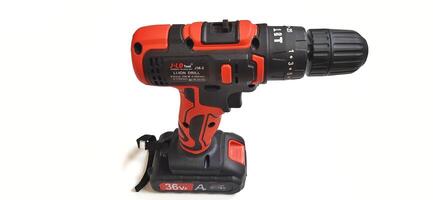 Electric red cordless screwdriver drill with charge the battery isolated on white background. Professional home repair tool. Bekasi, West Java, Indonesia - May 17 2024 photo