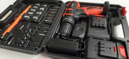 Electric red cordless screwdriver drill with charge the battery isolated on white background. Professional home repair tool. Bekasi, West Java, Indonesia - May 17 2024 photo