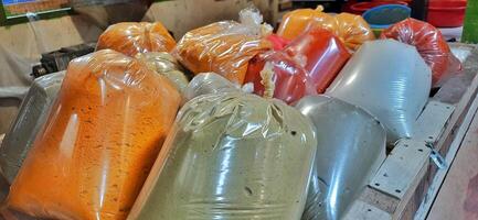 Various condiments or bumbu giling or bumbu halus ingredients in plastic packaging for cuisine, sold in Indonesian local market photo