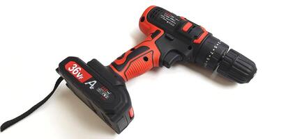 Electric red cordless screwdriver drill with charge the battery isolated on white background. Professional home repair tool. Bekasi, West Java, Indonesia - May 17 2024 photo