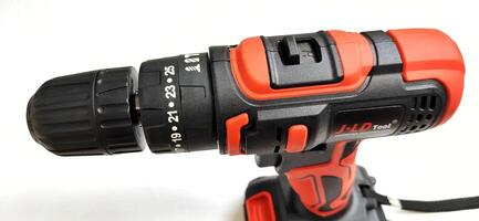 Electric red cordless screwdriver drill with charge the battery isolated on white background. Professional home repair tool. Bekasi, West Java, Indonesia - May 17 2024 photo