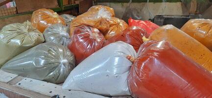 Various condiments or bumbu giling or bumbu halus ingredients in plastic packaging for cuisine, sold in Indonesian local market photo