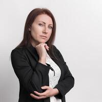 Formal portrait of confident businesswoman resting chin on fist and looking at camera photo