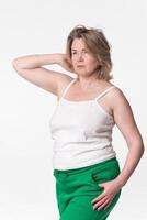 Portrait of chubby mature adult woman Generation X wearing cotton camisole and green jogging pants photo