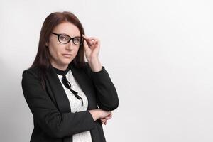 Formal portrait of well dressed businesswoman, wearing jacket and glasses, looking at camera photo