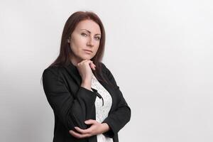 Formal portrait of confident businesswoman resting chin on fist and looking at camera photo