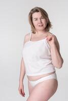 Woman in underwear on white background. Concept is promoting healthy lifestyle and body inclusivity photo