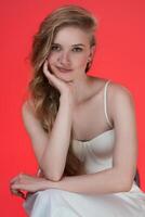 Headshot of young female fashion model from Generation Z resting chin on her palm, looking at camera photo